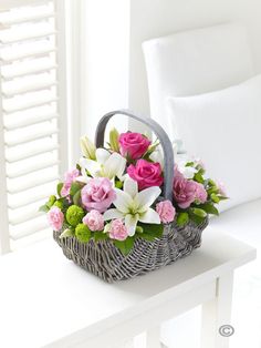 a basket filled with pink and white flowers