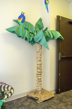 a palm tree made out of paper with two parrots sitting on top of it