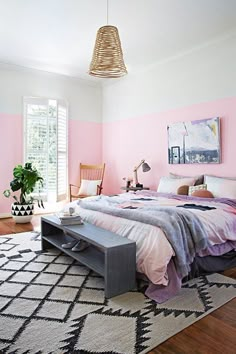 a bed room with a neatly made bed and pink walls