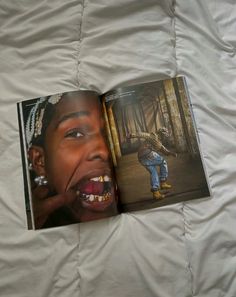 an open book showing a child's mouth and teeth on a bed with white sheets