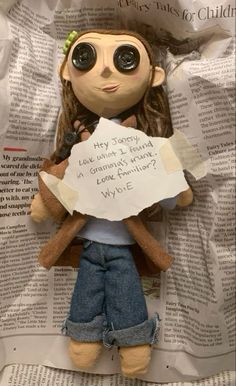 a stuffed doll holding a paper with writing on it