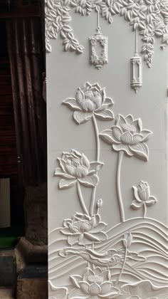 an intricately carved wall panel with flowers and leaves on the outside, in white