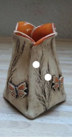 a ceramic vase with two butterflies on it