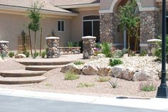 a house with stone steps leading up to the front door and landscaping area in front