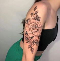 a woman's arm with a rose and butterfly tattoo on the left side of her arm