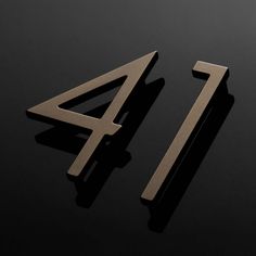 two metal numbers on a black surface with one in the shape of a number four