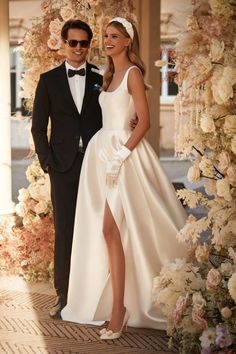 a man in a tuxedo and a woman in a wedding dress standing next to each other