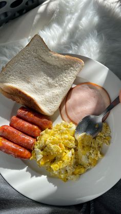 a white plate topped with eggs, sausage and toast