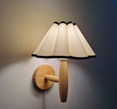 a lamp that is on the wall next to a light fixture with a wooden arm