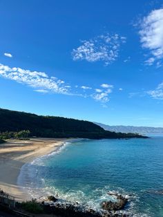 the beach is clear and blue with waves coming in