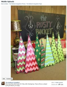 colorful christmas trees are lined up in front of a chalkboard with the words rusty bucket written on it