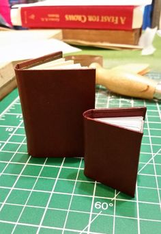 two brown books sitting on top of a green table