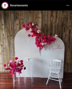 two vases filled with flowers sitting on top of a wooden floor next to a white chair