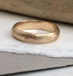 a gold wedding ring sitting on top of a white cloth