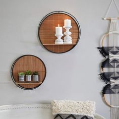 three circular wall shelves with candles on them