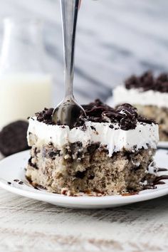 a piece of cake on a white plate with a fork in it and chocolate chips