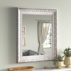 a white mantle with a mirror and vases on it