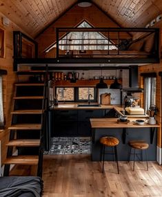 the interior of a tiny cabin with stairs leading up to an upper level kitchen area