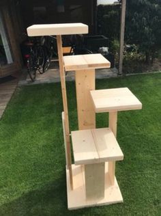 a wooden shelf sitting on top of green grass next to a bike parked in the background