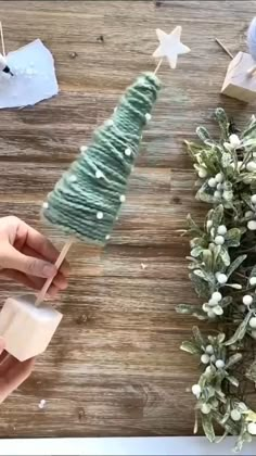 three small christmas trees on wooden blocks in front of a mirror