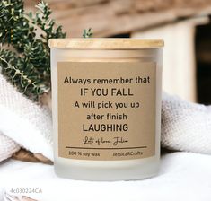 a candle sitting on top of a table next to a potted plant with a quote