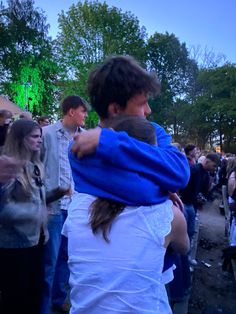 two people hugging each other in the middle of a crowd