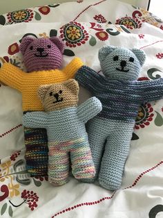 three crocheted teddy bears laying on top of a bed next to each other