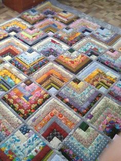 a very large quilt that is laying on the floor