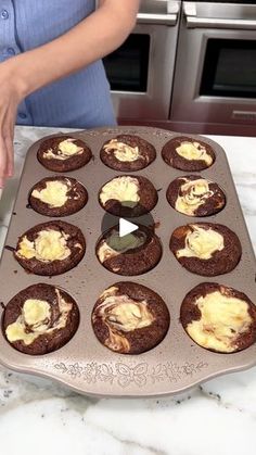 a woman is making cupcakes with frosting in the middle on a baking tray