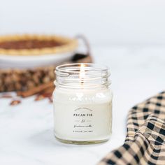 a candle sitting on top of a table next to a pie