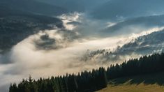 the mountains are covered in fog and clouds