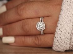 a close up of a person's hand with a diamond ring on their finger