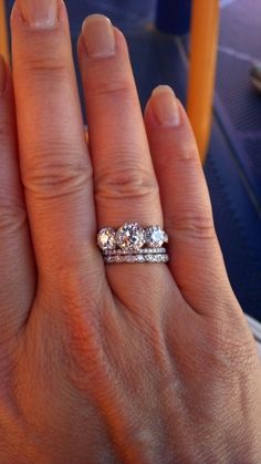 a woman's hand with three diamond rings on it