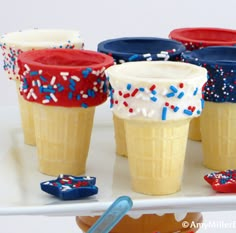 ice cream cones decorated with red, white and blue sprinkles on a tray