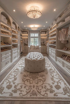 an elegant walk in closet with white furniture and chandelier