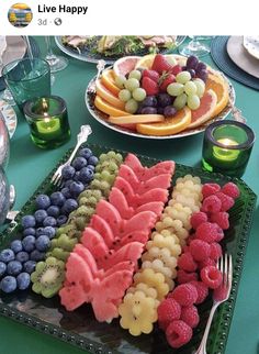 a table topped with plates of fruit and watermelon cut in half to look like animals