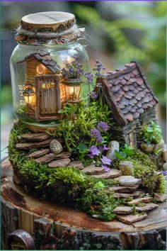 a glass jar filled with plants and small houses on top of a tree stump in the woods