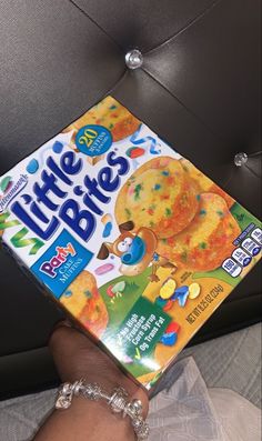 a hand holding a box of little bites cereal