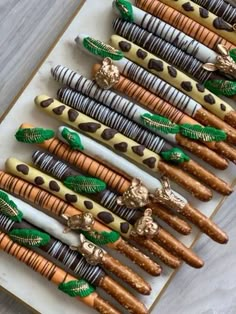 there are many different types of chocolate covered pretzels on the plate with gold and green decorations