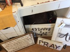 some signs are sitting on the floor next to a dresser and table with other items