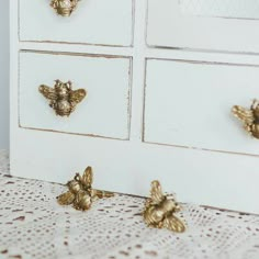 some gold bees are sitting on a white dresser