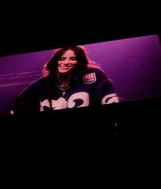 a woman standing in front of a purple screen