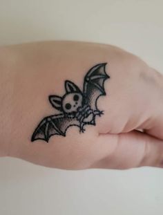 a small bat tattoo on the wrist