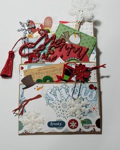 an assortment of christmas cards and tags on a white surface with snowflakes, ribbons, and tassels