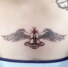 a woman's chest with angel wings and a cross on the top of it