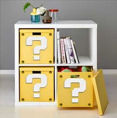 a white book shelf with yellow bins and question marks on it