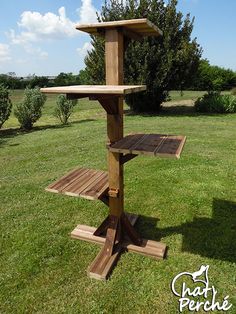 a wooden bird feeder in the grass