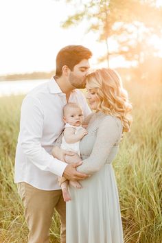 a man and woman holding a baby in their arms