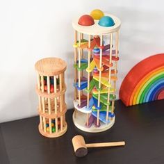 an assortment of wooden toys sitting on top of a table next to a rainbow rug