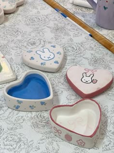 four heart shaped dishes sitting on top of a table